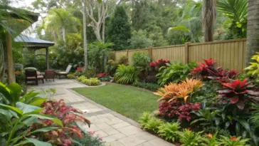 A shaded Queensland garden sanctuary featuring tropical shade plants arranged along a winding stone pathway. Native ferns, palms, and diverse foliage thrive beneath a wooden pavilion, creating a peaceful retreat typical of subtropical shade gardens in Queensland. The well-maintained path leads through layers of lush greenery, demonstrating ideal plant placement for shaded garden spaces.