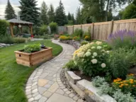 A clean and professional Backyard Layout featuring a winding natural stone walkway that leads past a raised cedar planter bed and built-in stone retaining walls overflowing with white hydrangeas, purple salvia, and bright orange marigolds toward a peaceful wooden gazebo.