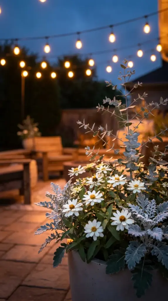 A glowing evening moon garden featuring white star zinnias and silver foliage under bistro lights.