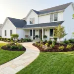 Beautifully landscaped front yard with high curb appeal featuring clean stone borders and dark mulch beds.