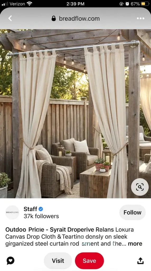 Heavy duty canvas drop cloth curtains used as outdoor drapery panels to decorate a wood fence line.