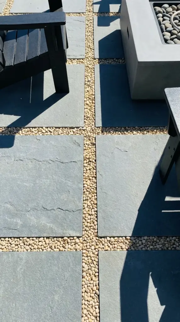 Modern patio design featuring large pavers and pea gravel for an affordable outdoor upgrade.