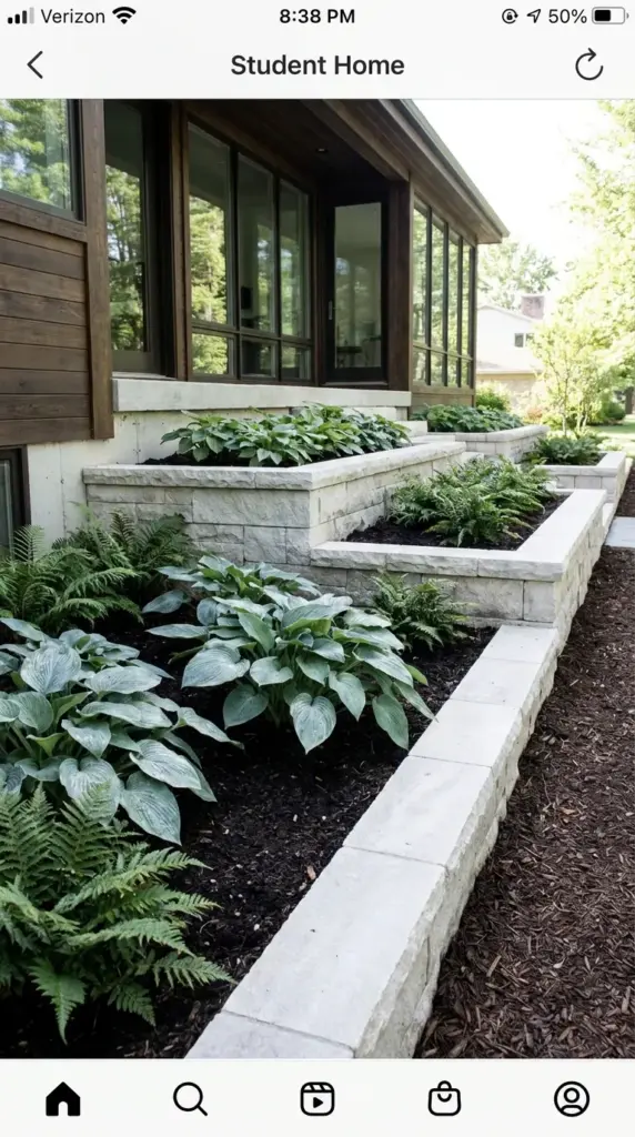 Modern raised garden beds built with light gray stone borders for shade plants.